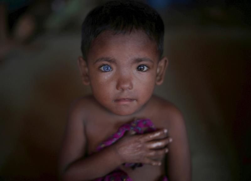 A Rohingya child who fled Myanmar listens to children sing Nov. 5 at a children's center in the Kutupalong refugee camp near Cox's Bazar