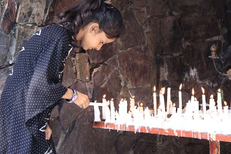 A young girl lights a candle at a Marian grotto in Pakistan. (Credit: Magdalena Wolnik via CNA)