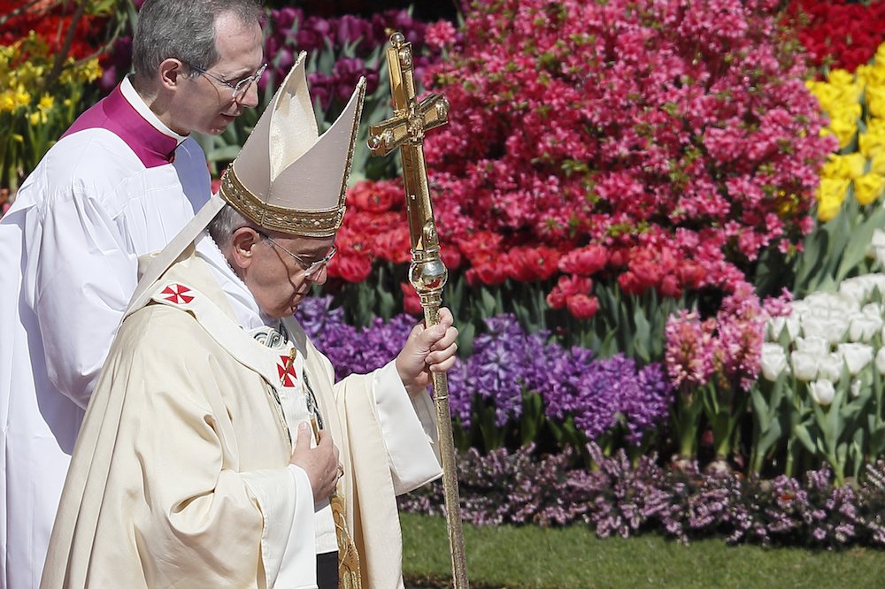 Pope Francis walks past flowers as he leaves Easter Mass in St. Peter's Square at the Vatican April 20