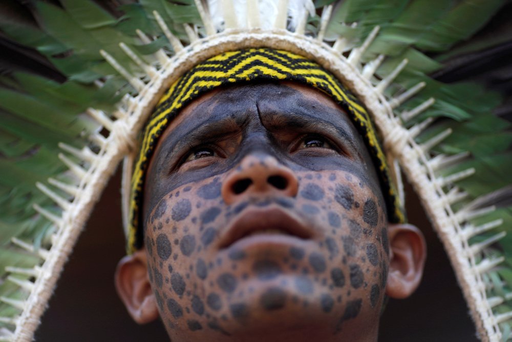 A member of the Shanenawa tribe observes an indigenous dance during a festival to celebrate nature and ask for an end to the burning of the Amazon