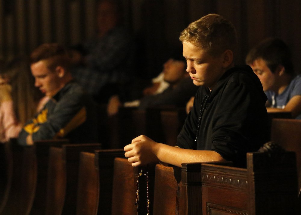 A teenager prays during a Holy Hour for high school students at Immaculate Conception Seminary in Huntington