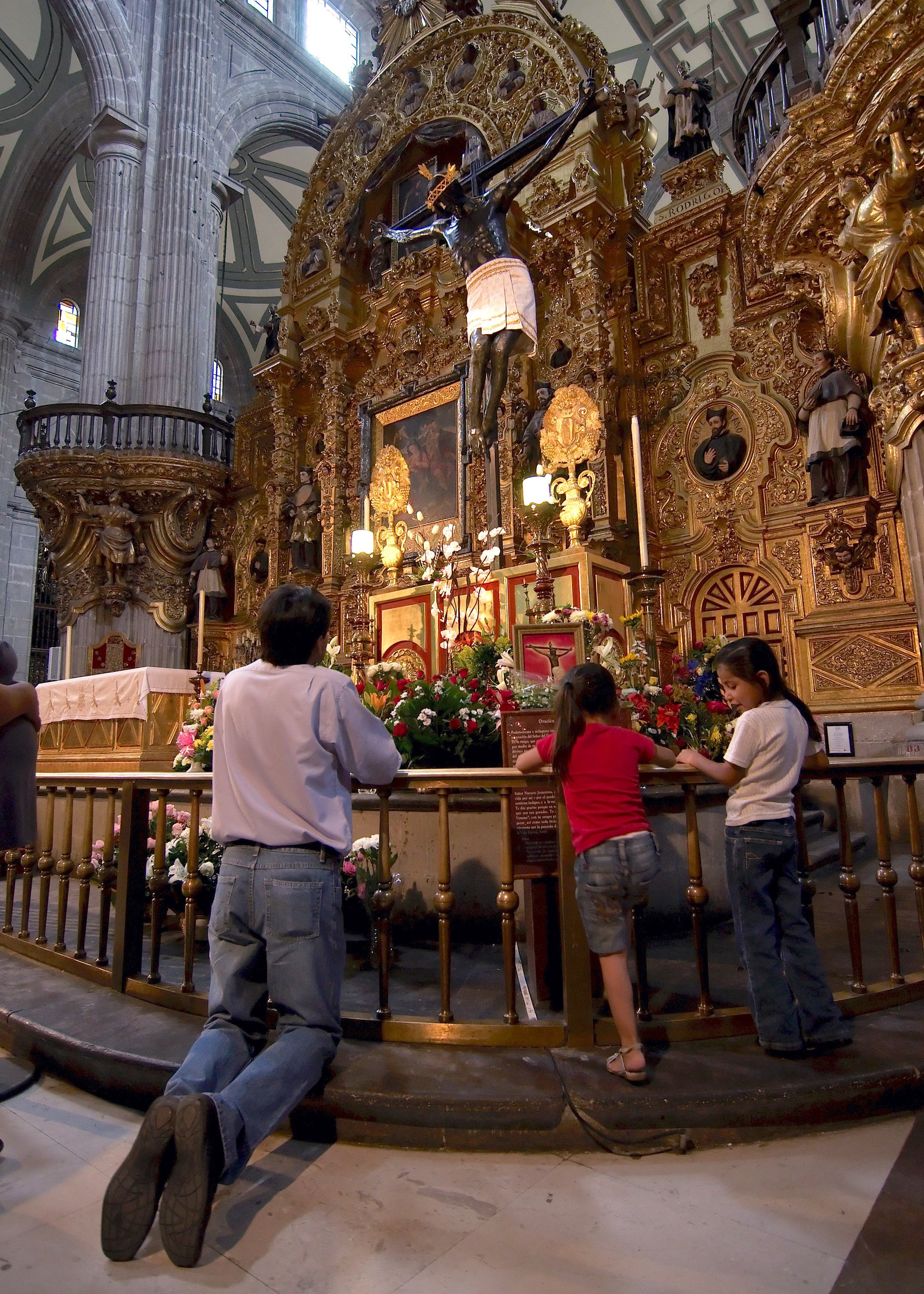 Visitors pray before the crucifix of “El Señor del Veneno” at the Cathedral of Mexico City. (ROBERTO MICHEL/SHUTTERSTOCK)