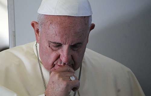 Pope Francis prays with journalists on the papal flight en route to South Korea on Aug. 14