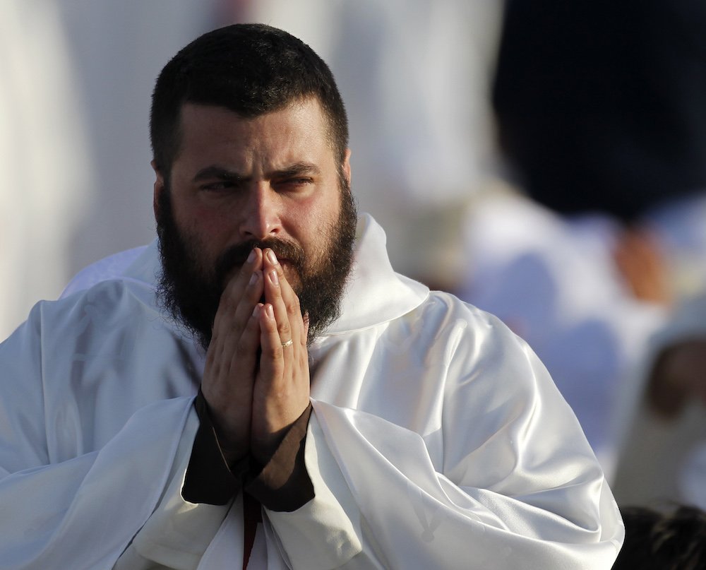 A priest prays during Mass in Madrid Aug. 21