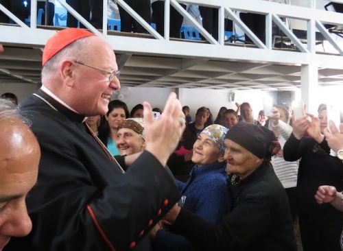Cardinal Dolan greets Iraqis in the village of Inishke before Mass on April 10
