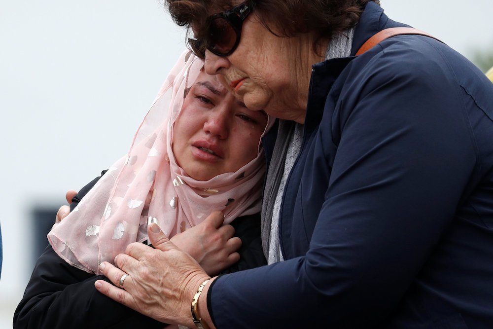 People embrace as they pay respects outside Al Noor Mosque in Christchurch