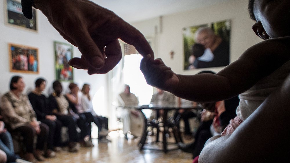 Pope Francis sits with women rescued from prostitution and their supporters at the Pope John XXIII Community in Rome Aug.12