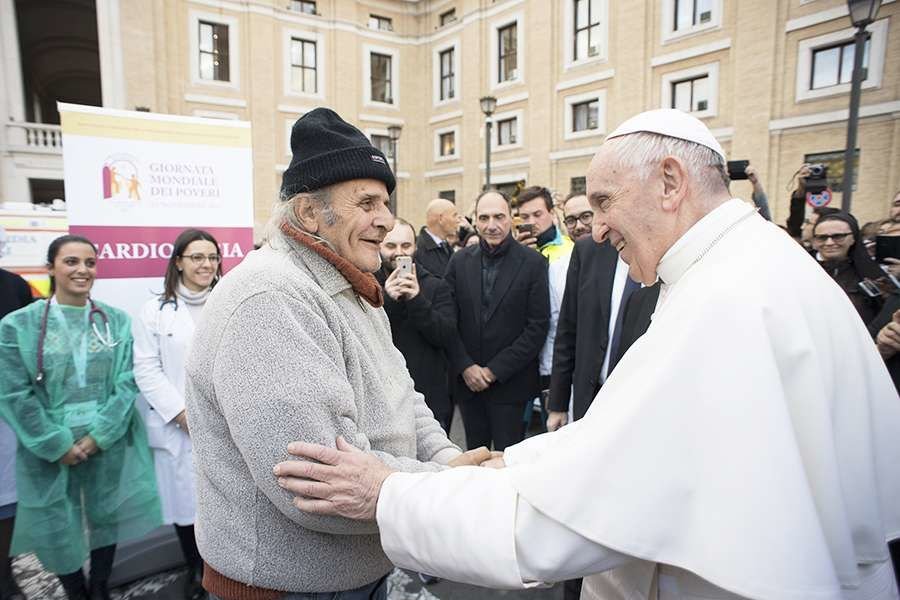 Pope Francis greets a participant in the World Day of the Poor in Rome