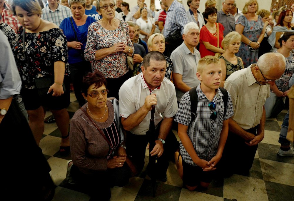 Worshippers pray during celebrations on the feast of the Assumption