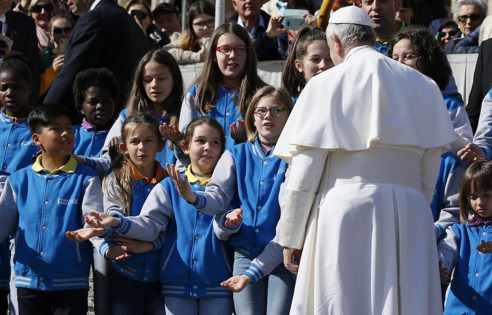 Pope Francis greets a group of children during his general audience in St. Peter's Square at the Vatican March 6
