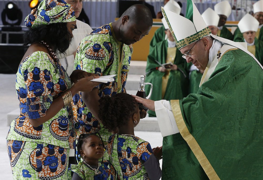 Pope Francis blesses a girl as her family presents offertory gifts during the closing Mass of the World Meeting of Families along Benjamin Franklin Parkway in Philadelphia Sept. 27