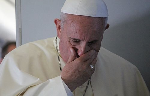Pope Francis prays with journalists on the papal flight en route to South Korea on Aug. 14
