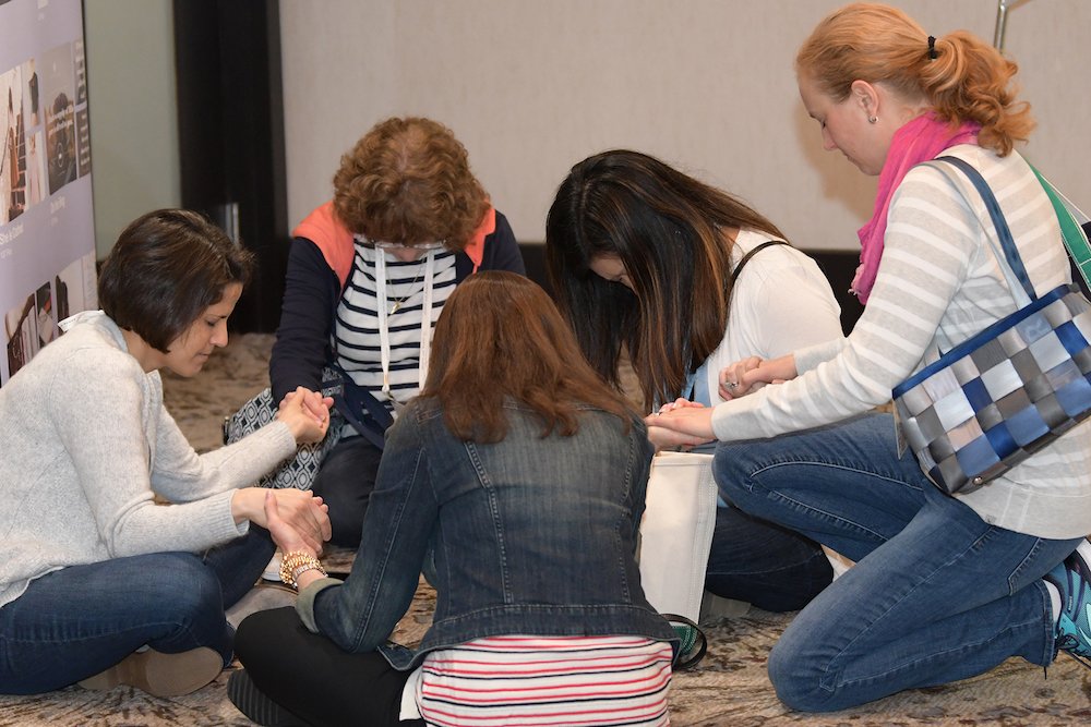 A group of women gather for prayer during Bible study in this undated photo. A new survey released by the Walking With Purpose program shows that women who participate in Bible study courses reported being happier