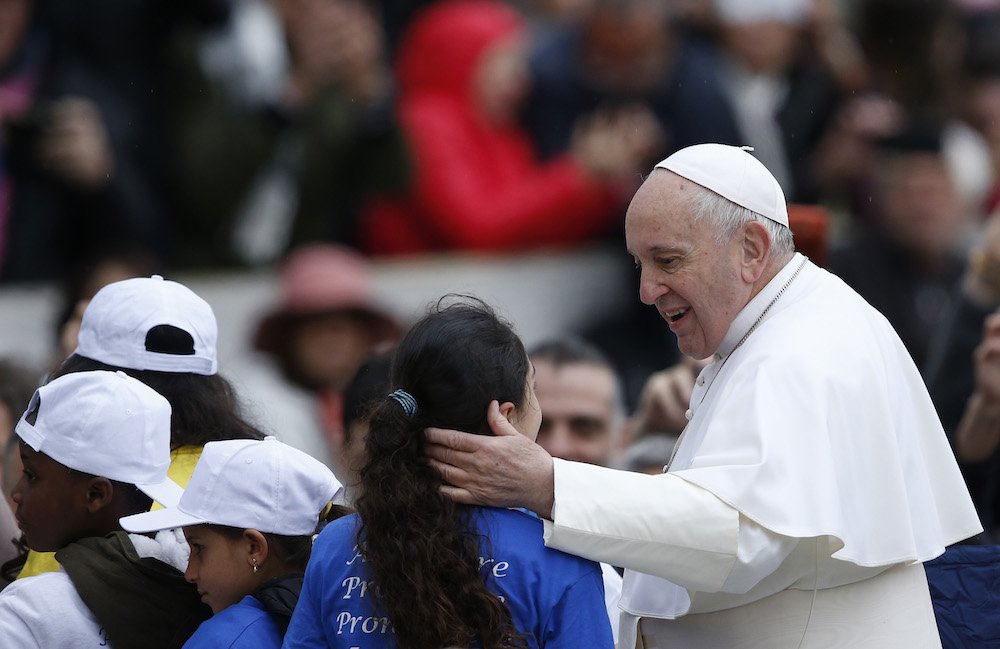 Pope Francis greets a girl who rode in the popemobile during his general audience in St. Peter's Square at the Vatican May 15