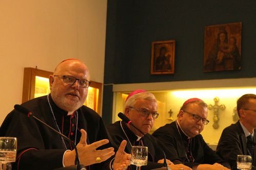 Cardinal Reinhard Marx of Munich and Freising (L) speaks at a press conference held by German bishops at the Teutonic College