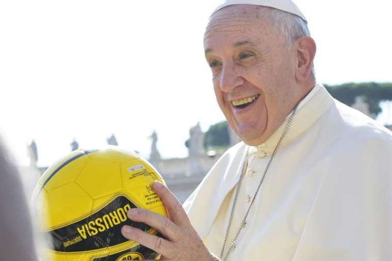 Pope Francis holds a soccer ball in St. Peter's Square during the Wednesday general audience on Aug. 26