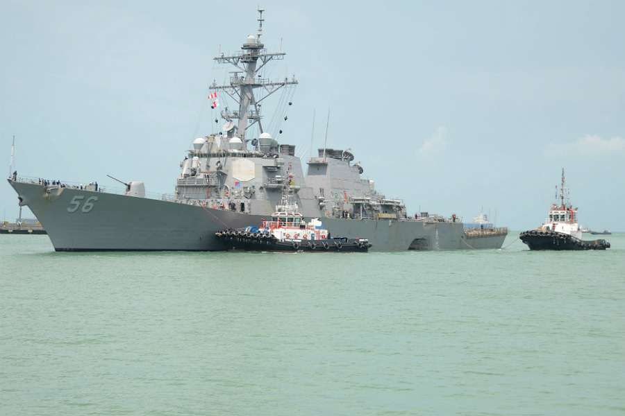 The USS John S. McCain is steered to Changi Naval Base in Singapore following a collision with a mercant vessel