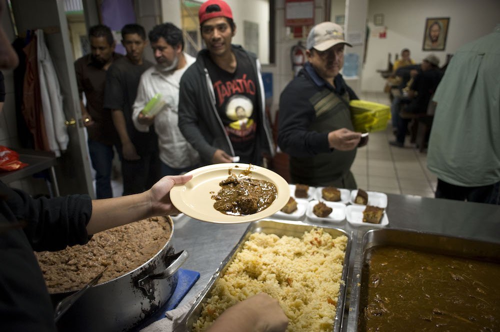 People are seen waiting in line for dinner in this April 25