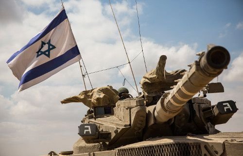 An Israeli tank moves positions near the Israeli-Gaza border the morning of July 18
