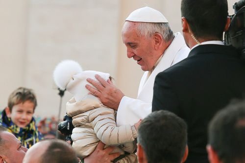 Pope Francis embraces a child at the general audience in St. Peter's Square