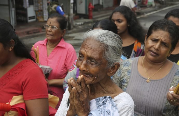 Sri Lankans light candles and pray outside St. Anthony's Church in Colombo