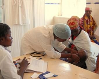 A nurse at a clinic in Angola's Huambo province checks a patient and her baby. Credit: USAID/Alison Bird.