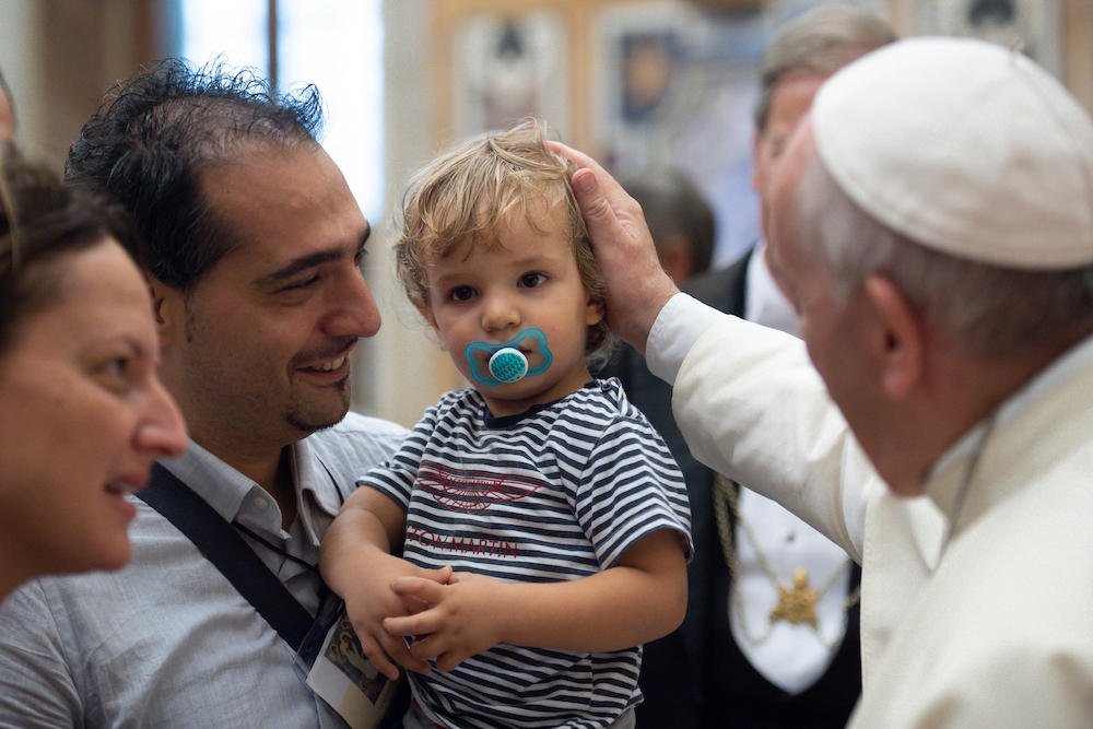 Pope Francis greets a child Sept. 13 at the Vatican during a meeting with people who were to take part in the conference