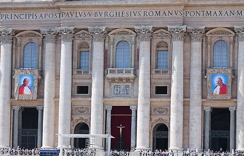 Tapestries of Sts. John XXIII and John Paul II hang from the facade of St. Peter's Basilica shortly before their canonizations. Credit: Lauren Cater/CNA.
