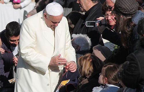 Pope Francis blesses a rosary for a pilgrim in St. Peter's Square during the Wednesday general audience on Dec. 4
