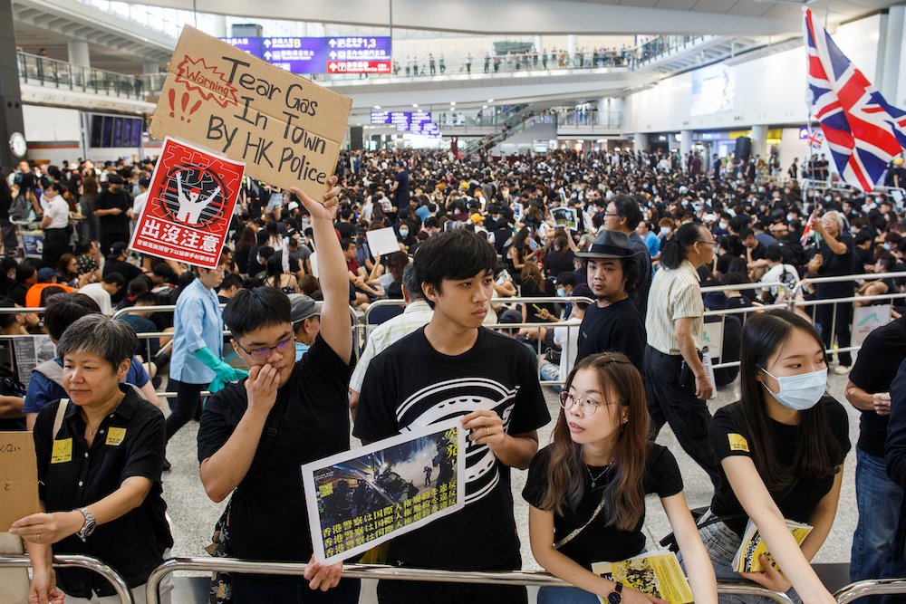 Anti-extradition bill protesters hold placards for arriving travelers during a protest at Hong Kong International Airport Aug. 9