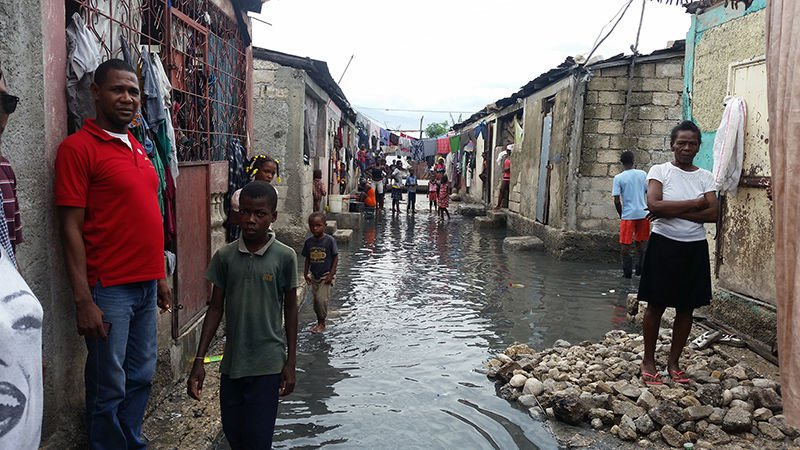 Residents stand outside their homes Oct. 5 in Cite Soleil