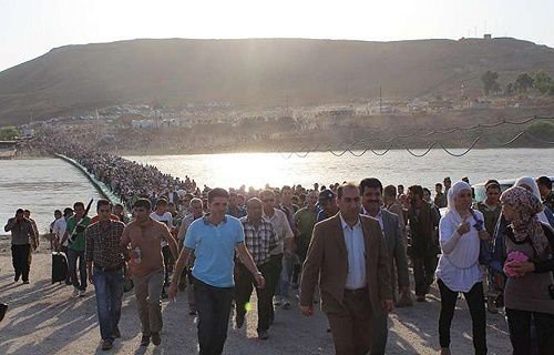 Thousands of Syrians streamed across a bridge over the Tigris River
