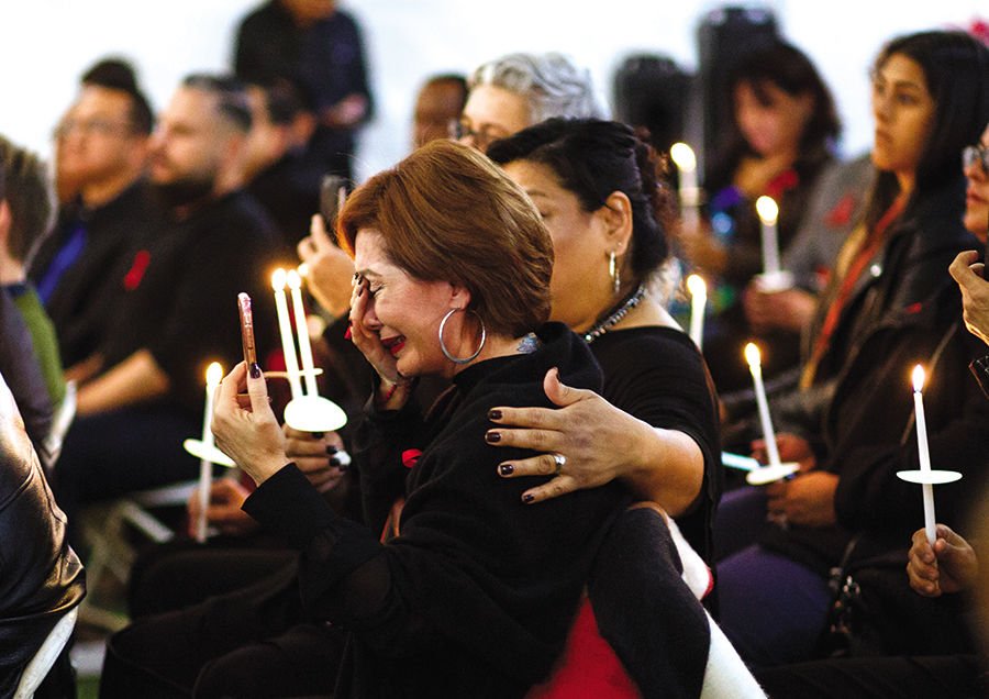 Visitors hold candles during a World AIDS Day gathering at the Las Memorias AIDS Monument in Los Angeles on Dec. 1. (CNS PHOTO/EUGENE GARCIA
