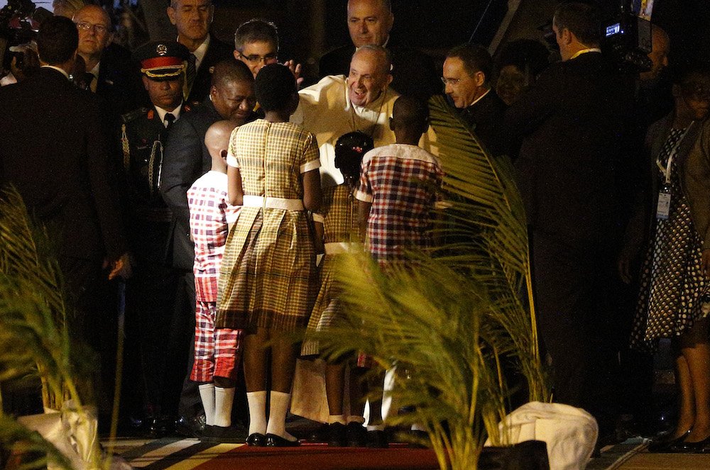 Pope Francis is pictured with Mozambican President Filipe Nyusi as he greets children at the airport in Maputo