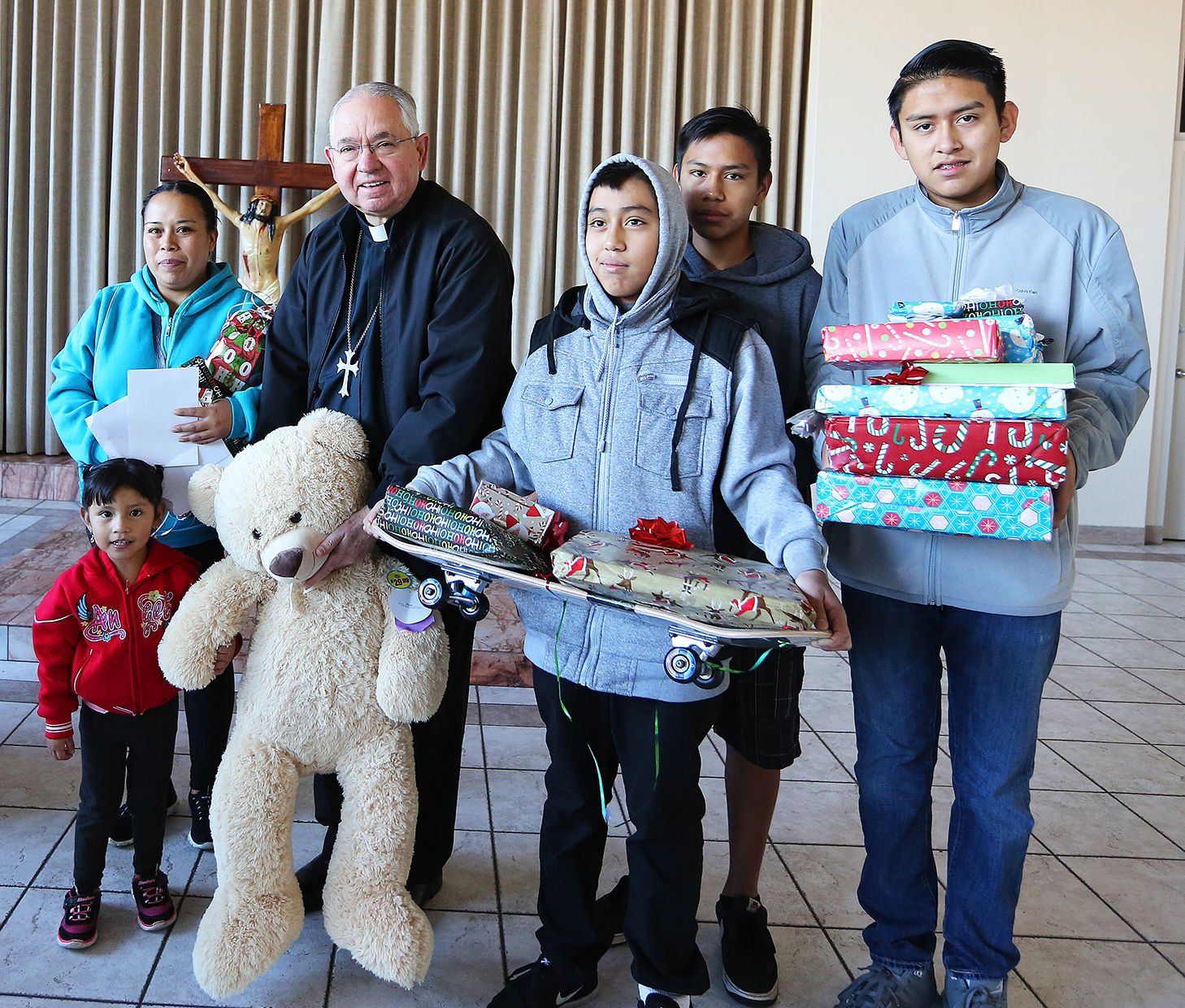 Archbishop José H. Gomez with one of hundreds of a low-income families from Downtown L.A. whose Christmas season was brightened in 2016 thanks to the Adopt-A-Family program. (photo/Victor Alemán)