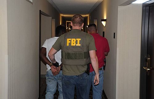 A suspect is taken into custody by FBI agents in Jackson