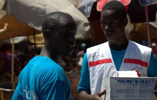 Health workers from UNICEF and partners visit the crowded Marché Niger to teach families in Guinea to protect against Ebola. Credit: UNICEF Guinea via Flickr (CC BY 2.0).