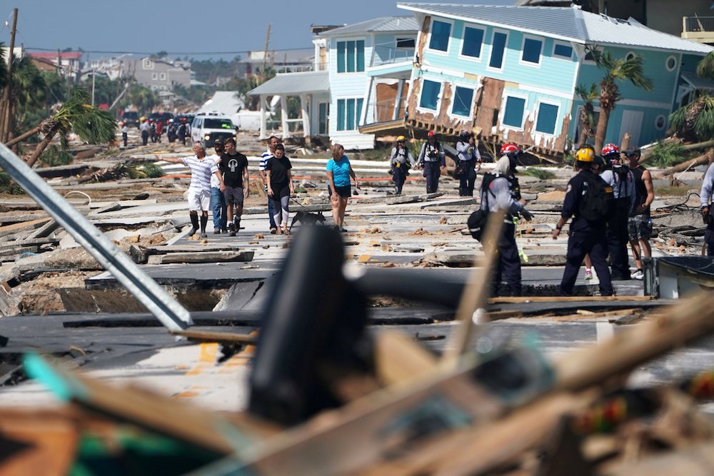 First responders and residents walk amid debris and destroyed homes Oct. 11 after Hurricane Michael swept through Mexico Beach