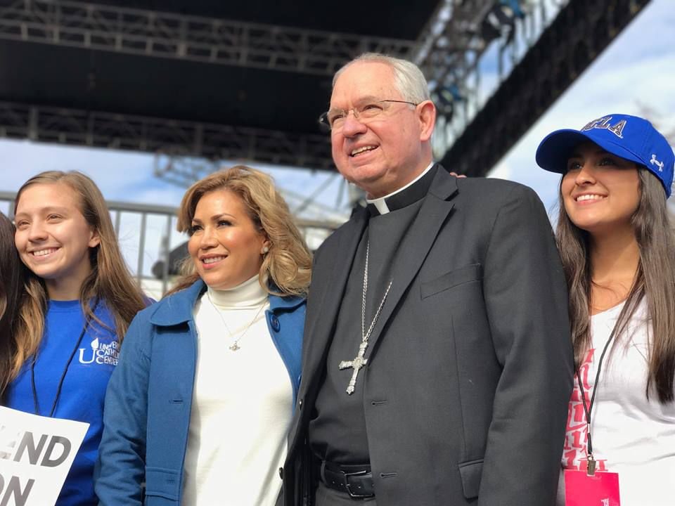 Archbishop José H. Gomez poses for a photo with OneLife LA participants Li and Lianna Rebelledo at Exposition Park in Los Angeles on January 21