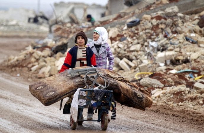 Syrian children transport their salvaged belongings from their damaged house in Doudyan