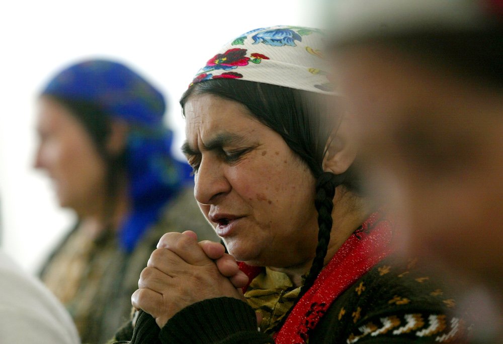 A Romanian Roma woman prays in a church in Sibiu some 173 miles northwest of Bucharest