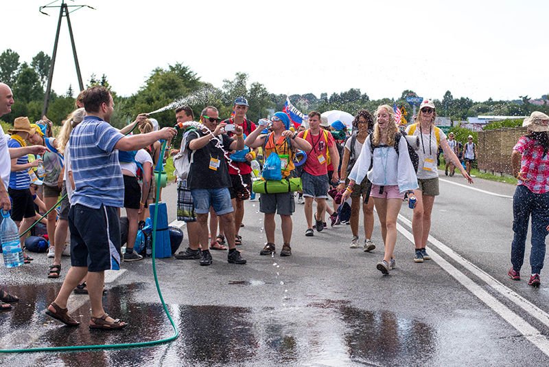 WYD pilgrims being cooled and refreshed by locals spraying water from hoses outside of Krakow in July. (photo/Suzana Yu)