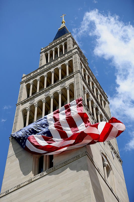 A large American flag hanging from the bell tower of the National Shrine of the Immacualte Conception in Washington blows in the wind prior to a July 4