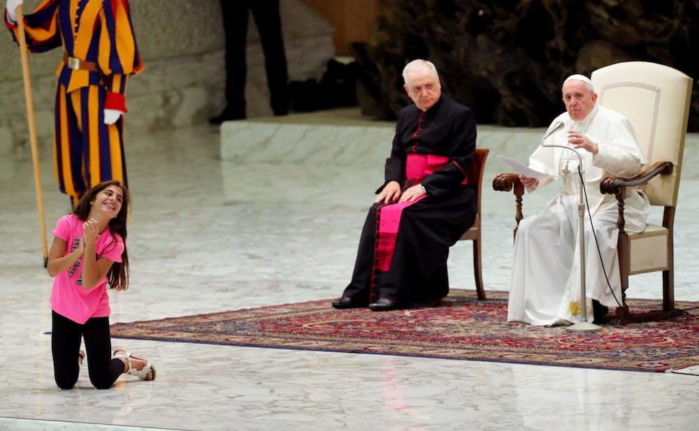 A girl smiles as Pope Francis leads his general audience in Paul VI hall at the Vatican Aug. 21