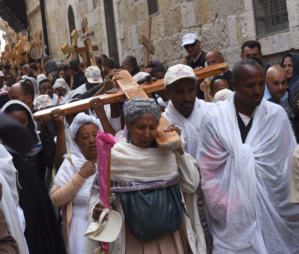Christians from Ethiopia carry a cross during a procession on the Via Dolorosa