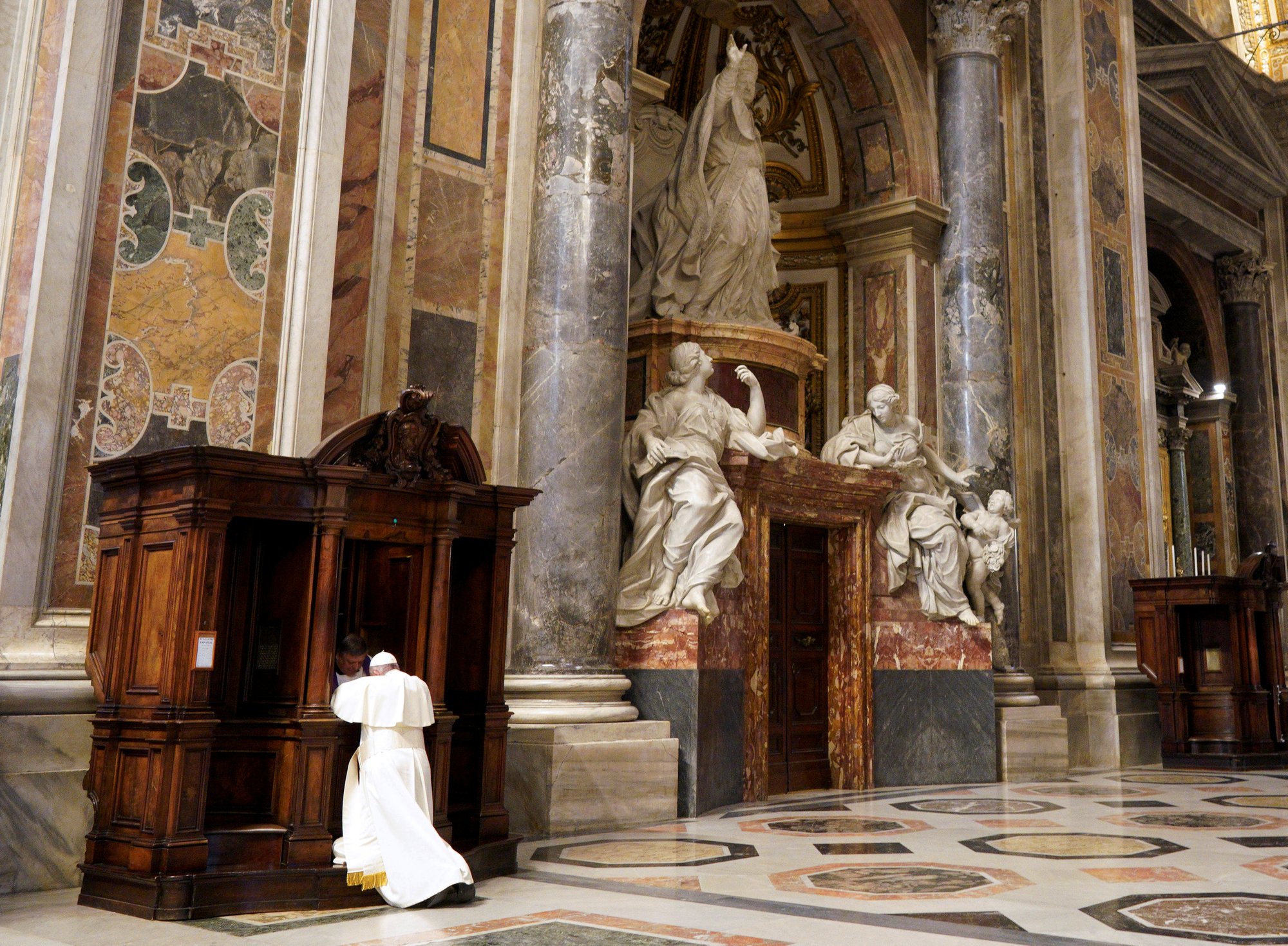 A priest hears Pope Francis' confession during a Lenten penance service in St. Peter's Basilica at the Vatican March 29