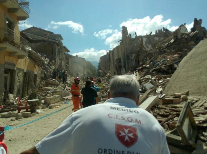 Rescue workers from the Sovereign Military Order of Malta assist in an earthquake affected area