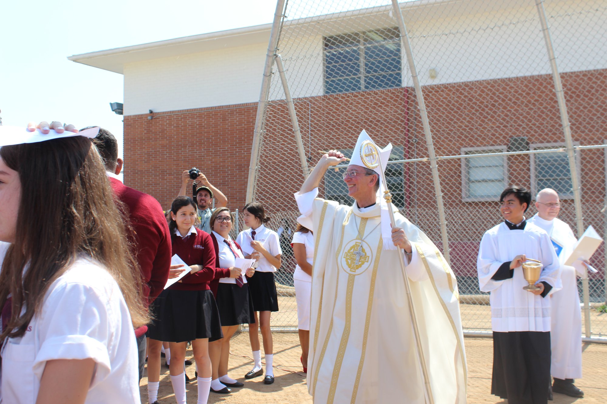 Bishop Marc Trudeau sprinkles holy water to bless the school's new field. (KIMBERLY TEJAS/ST PIUS X-ST. MATTHIAS)  