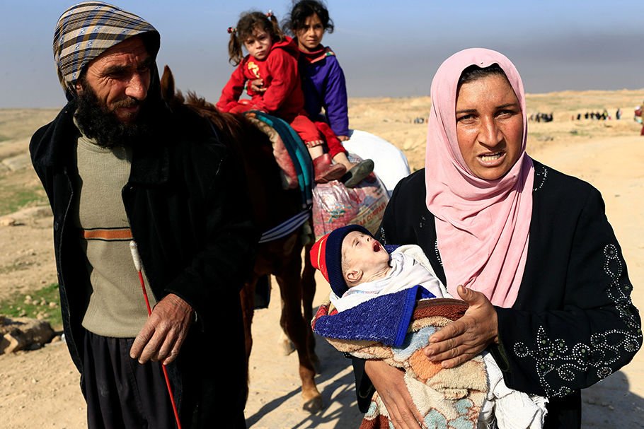 A displaced Iraqi woman carries her severely dehydrated 5-month-old child in Mosul. The woman fled her home during a battle between Iraqi forces and Islamic State militants. (CNS photo/Thaier Al-Sudani