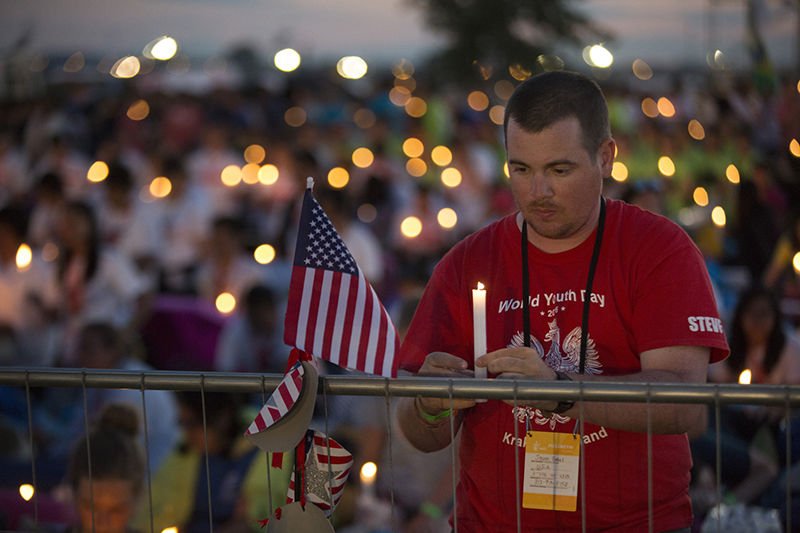World Youth Day pilgrims hold candles during eucharistic adoration with Pope Francis at the July 30 prayer vigil at the Field of Mercy in Krakow